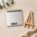 Engraved glass quote mirror with wood easel on a light wood desk